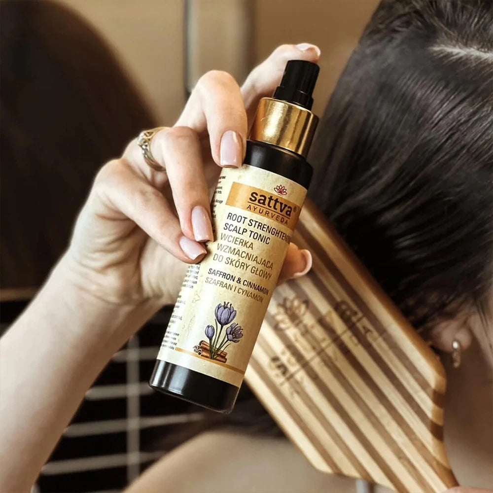 Loção para Couro Cabeludo com Açafrão e Canela da Sattva Ayurveda rodeado por fios de açafrão e paus de canela, destacando a nutrição natural e herbal para cabelos saudáveis e cuidados Ayurvédicos.