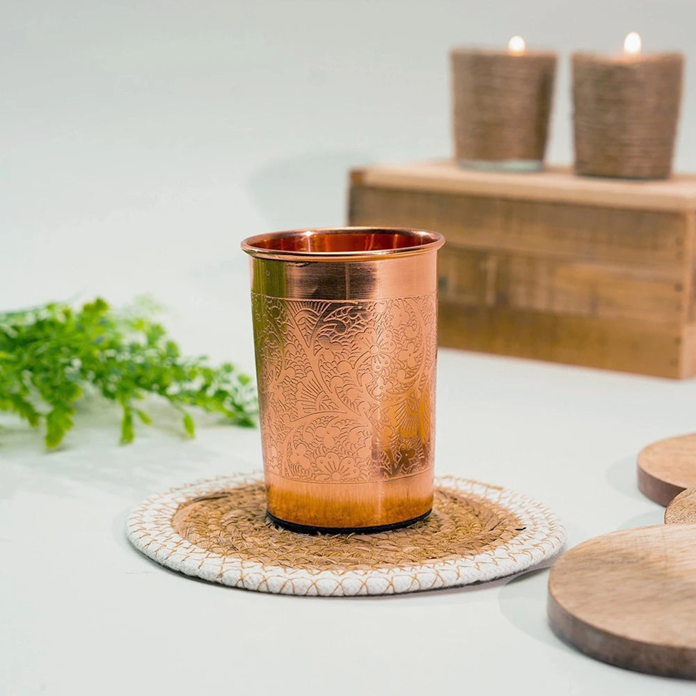 Copo de cobre artesanal com padrão floral gravado, perfeito para práticas ayurvédicas e hidratação diária com elegância.