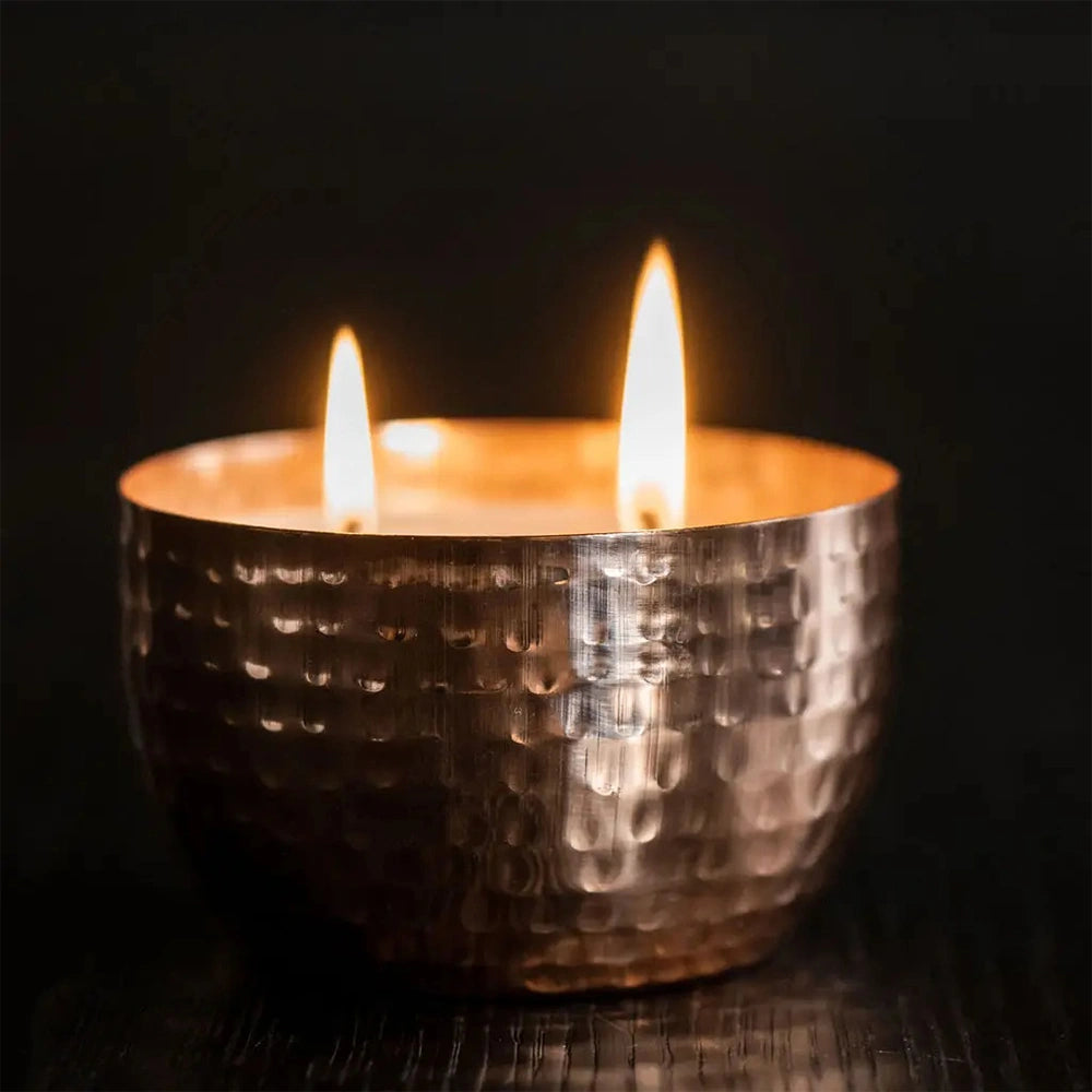 Vela natural com lavanda e erva-príncipe em recipiente de cobre para relaxamento e decoração